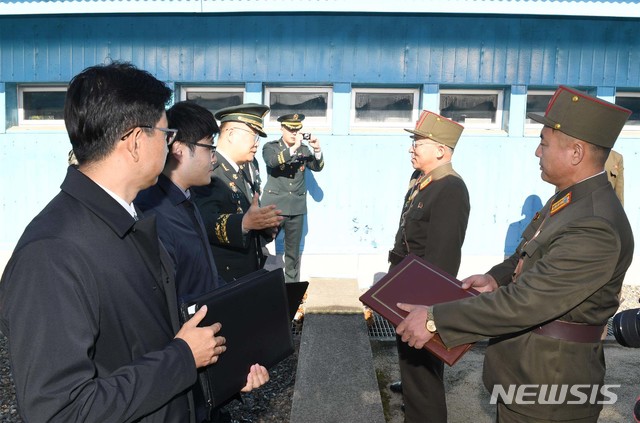 【서울=뉴시스】 12일 경기도 파주시 판문점 공동경비구역 군사분계선에서 남북 군사 당국이 9·19 군사합의 이행을 위한 '남북군사실무접촉'에 앞서 이야기를 하고 있다. 이날 실무접촉에는 우리측 조용근 육군대령과 관련 실무담당관 등 총 4명이, 북측 엄창남 육군대좌와 관련 실무담당관 등 총 4명이 참가했다. 2018.10.12. (사진=국방부 제공) photo@newsis.com