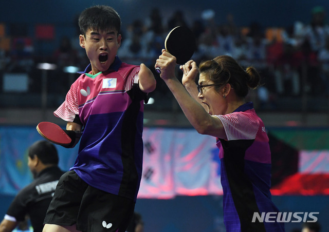 【자카르타(인도네시아)=뉴시스】사진공동취재단 = 남북 탁구단일팀 '코리아' 박홍규(오른쪽)와 북측 김영록 선수가 12일 오후(현지시간) 인도네시아 자카르타 에코벤션 안촐에서 열린 '2018 인도네시아 장애인아시아경기대회' 중국과의 남자 탁구 단체전(장애등급 TT 6-7) 마지막 경기 1게임에서 득점에 성공하자 포효하고 있다. 한편, 단일팀은 풀리그 방식으로 진행된 단체전에서 3승1패를 거두며 동메달을 확보했으며 13일 진행되는 중국과 일본의 경기결과에 따라 메달 색이 최종 결정된다. 2018.10.12. photo@newsis.com