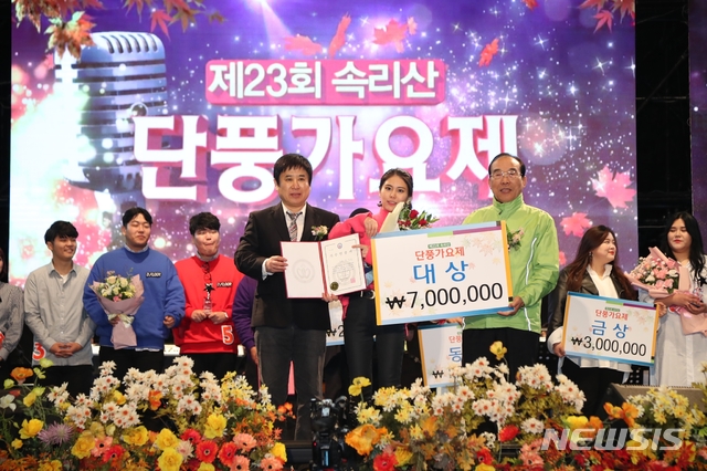 【보은=뉴시스】이성기 기자 = 지난 13일 밤 충북 보은 속리산잔디공원에서 열린 '23회 속리산 단풍가요제’에서 대상을 받은 박지희 씨(가운데 분홍 옷)가 정상혁 보은군수로부처 수상한 후 기념촬영을 하고 있다.2018.10.14(사진=보은군 제공) photo@newsis.com