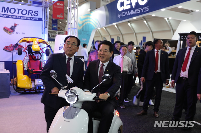 【영광=뉴시스】 = 사진은 전남 영광군이 올해 처음으로 개최한 '2018 영광 국제 스마트 e-모빌리티엑스포' 행사장 모습. 행사장을 찾은 김영록 전남지사(오른쪽)와 김준성 영광군수가 전동스쿠터 앞에서 기념 촬영을 하고 있다. 2018.12.20&nbsp; (사진=뉴시스DB)