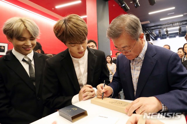 【파리(프랑스)=뉴시스】전신 기자 = 문재인 대통령이 14일(현지시간) 프랑스 파리 르 트레지엠 아트 공연장에서 열린 한-불 우정콘서트 관람을 마친 후 방탄소년단에게 선물한 시계에 사인하고 있다. 2018.10.15.photo1006@newsis.com