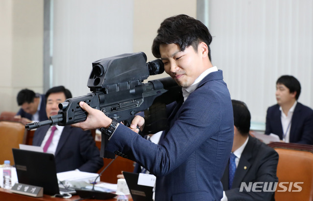 【서울=뉴시스】홍효식 기자 = 더불어민주당 김병기 의원실의 관계자가 15일 오후 서울 여의도 국회에서 열린 국방위원회의 방위사업청, 국방과학연구소, 국방기술품질원 등에 대한 국정감사에서 K-11 복합소총을 보이고 있다. K-11은 5.56㎜ 소총과 20㎜ 공중폭발탄을 하나로 일체화시킨 이중 총열 방식의 무기로 개발 당시 찬사를 들었으나 사격통제장치 균열 발생 등의 결함이 나타나면서 납품이 중단됐다. 2018.10.15. yesphoto@newsis.com