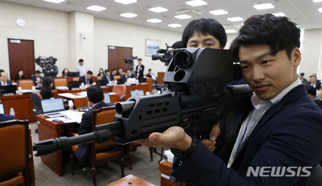 【서울=뉴시스】홍효식 기자 = 더불어민주당 김병기 의원실의 관계자가 지난달 15일 오후 서울 여의도 국회에서 열린 국방위원회의 방위사업청, 국방과학연구소, 국방기술품질원 등에 대한 국정감사에서 K-11 복합소총을 보이고 있다. K-11은 5.56㎜ 소총과 20㎜ 공중폭발탄을 하나로 일체화시킨 이중 총열 방식의 무기로 개발 당시 찬사를 들었으나 사격통제장치 균열 발생 등의 결함이 나타나면서 납품이 중단됐다. 2018.10.15. yesphoto@newsis.com