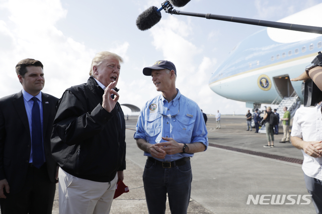 【이글린 공군기지(미 플로리다주)=AP/뉴시스】도널드 트럼프 미 대통령이 15일 허리케인 마이클로 피해를 입은 지역을 방문하기 위해 플로리다주 이글린 공군기지에 도착한 후 릭 스콧 플로리다 주지사(오른쪽)와 함께 기자들에게 이야기하고 있다. 트럼프는 이날 백악관에서 플로리다로 향하기 전 북한 문제는 복잡하다면서도 매우 잘 진행되고 있다고 말했다. 2018.10.16