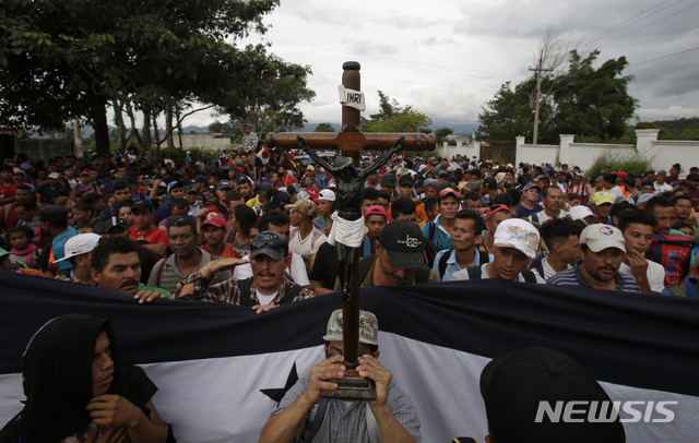 【 에스키풀라스(과테말라) = AP/뉴시스】 멕시코를 거쳐 미국으로 가려는 온두라스 이민들의 캐러밴이 국경부근에 몰려있는 동안 한 이민남성이 에스키풀라스의 검은 예수상의 복제품을 들고 기도를 올리고 있다.&nbsp;&nbsp;&nbsp; 