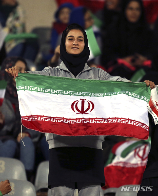 【테헤란=AP/뉴시스】이란 테헤란 아자디 스타디움에서 16일(현지시간) 한 여성 축구팬이 이란과 볼리비아 대표팀 간 평가전을 관람하며 국기를 흔들고 있다. 이란 정부는 이날 여성들의 축구경기 관람을 허용했다. 이는 1979년 이슬람 혁명 이후 처음이다. 2018.10.17