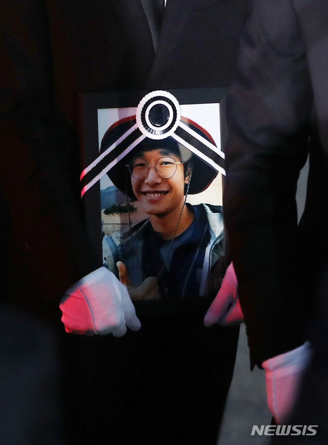 【인천공항=뉴시스】박주성 기자 = 히말라야 등반 도중 사망한 고(故) 이재훈 대원의 시신이 17일 오전 인천 중구 인천국제공항 화물청사 내 대한항공 화물터미널로 나와 유족이 고인의 영정을 들고 있다. 2018.10.17. park7691@newsis.com