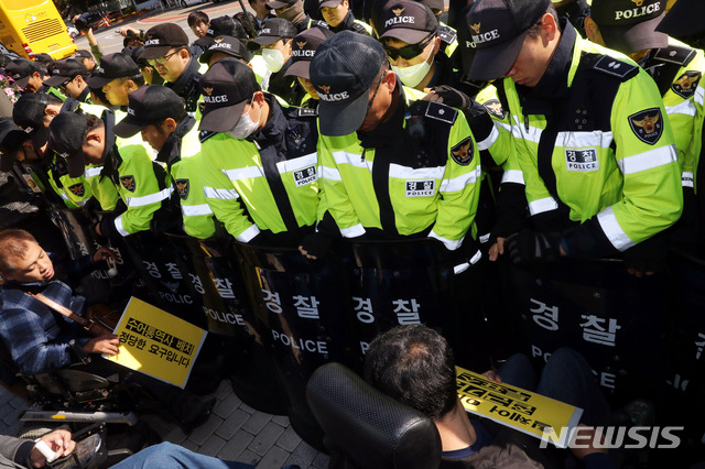 【서울=뉴시스】조성봉 기자 = 17일 오전 서울 종로구 청와대 인근 분수대 앞에서 장애인 참정권 보장 약속 이행 촉구 기자회견을 마친 전국장애인차별철폐연대 등 장애인단체 회원들이 '장애인참정권 보장 약속 이행' 요구서를 전달하기 위해 청와대로 향하자 경찰이 제지하고 있다. 2018.10.17.suncho21@newsis.com