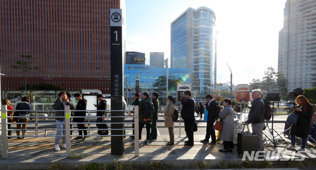 【서울=뉴시스】배훈식 기자 = 카카오의 카풀 서비스에 반발해 택시업계가 파업에 돌입한 18일 오전 서울 용산구 서울역 앞 택시승강장에 시민들이 길게 줄을 서고 있다. 2018.10.18.&nbsp; dahora83@newsis.com