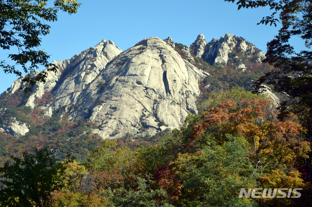 【서울=뉴시스】 서리가 내린다는 상강 절기를 나흘 앞둔 19일 백운대 만경대 노적봉 등 북한산 정상부 아래로 단풍이 절정을 이뤄 아름다운 경치를 보여주고 있다. 2018.10.19 (사진=이형기 알피니스트 제공) hipth@newsis.com