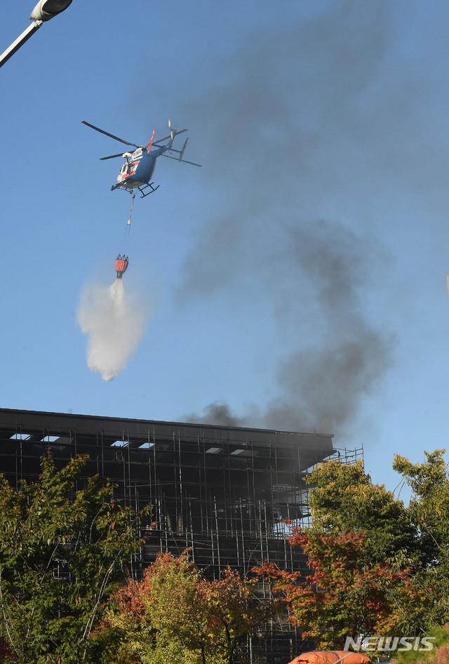 【대전=뉴시스】함형서 기자= 19일 오후 대전 서구 관저동에 있는 관저다목적체육관 건립공사현장에서 화재가 발생해 출동한 소방헬기가 잔불을 끄고 있다. 이 화재로 다행히 사망자는 없으나 연기 흡입등으로 작업중이던 인부 11명이 병원으로 이송돼 치료를 받고 있다. 2018.10.19.foodwork23@newsis.com