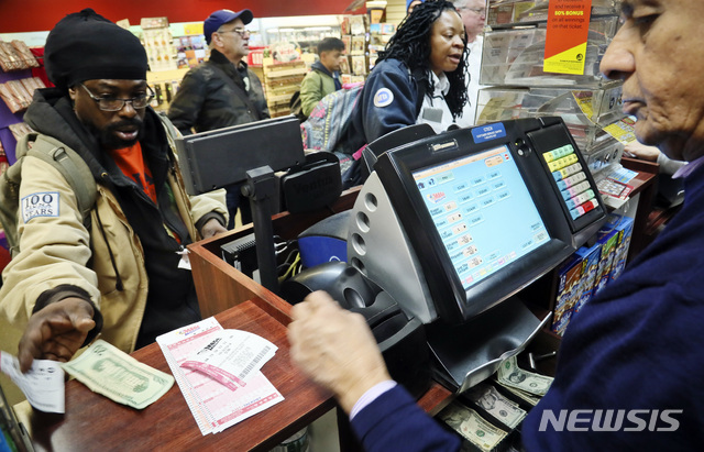 【뉴욕=AP/뉴시스】지난 19일 뉴욕의 한 복권 판매소에서 사람들이 10억 달러(1조1325억원)의 당첨금이 걸린 메가 밀리언 복권을 구입하고 있다. 2018.10.21