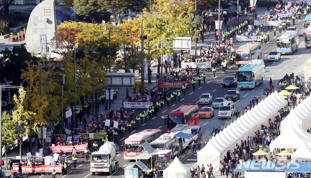 【서울=뉴시스】조성봉 기자 = 20일 오후 서울 종로구 광화문 시민열린마당에서 예멘인 수용 결정 반대집회를 마친 참석자들이 '가짜난민 추방'이라고 쓴 플래카드를 들고 광화문 네거리쪽으로 행진하고 있다. 2018.10.20.suncho21@newsis.com
