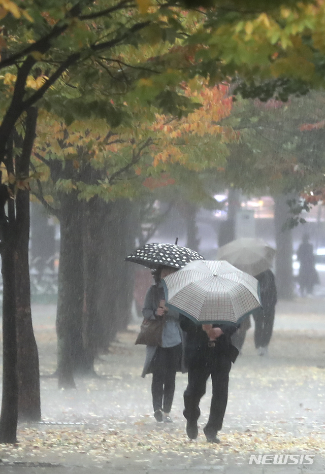 【서울=뉴시스】최진석 기자 = 서리가 내리는 시기를 뜻하는 절기 상강인 23일 오전 서울 영등포구 여의도에서 시민이 내리를 비를 맞으며 발걸음을 재촉하고 있다. 2018.10.23.myjs@newsis.com