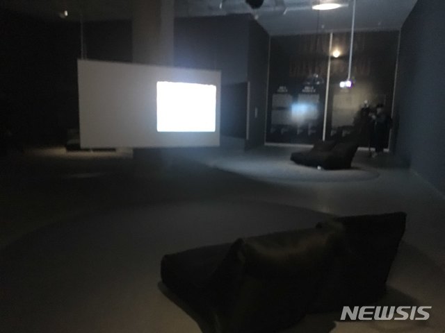 【서울=뉴시스】 박현주 미술전문기자 = 독일 영화 및 비디오아트의 거장 하룬 파로키 회고전은 마치 어두운 게임방이나 영화방처럼 연출되어 앉아서 작품을 볼수 있다.