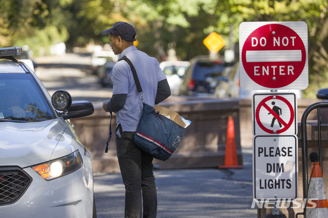 【워싱턴 = AP/뉴시스】 워싱턴 시내 오바마 전대통령 자택 부근에서 우편배달부 한 명이 24일 (현지시간) 편지를 배달하러왔다가 검문을 받고 있다.&nbsp; 미 대통령비밀 경호국 정복 부대는 이 날 시내에서 오바마와 힐러리 클린턴에게 배달된 폭발물에 대한 대대적인 수사를 벌였고, 앞으로는 법의학적 조사를 진행한다고 밝혔다.&nbsp;&nbsp; 