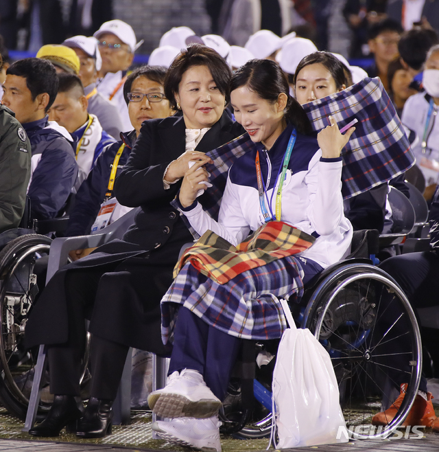 【익산=뉴시스】전신 기자 = 문재인 대통령 부인 김정숙 여사가 25일 오후 전북 익산시 익산종합운동장에서 열린 제38회 전국장애인체육대회 개회식에서 김선미 선수의 어깨에 담요를 둘러주고 있다. 2018.10.25. photo1006@newsis.com