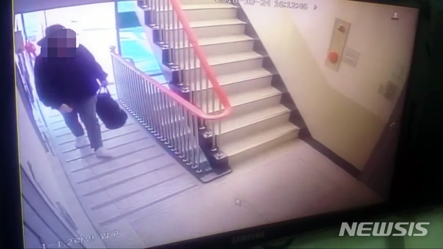 【부산=뉴시스】 하경민 기자 = 부산 사하경찰서는 부산의 한 아파트에서 일가족 4명과 용의자로 추정되는 남성 등 5명이 숨진 채 발견해 수사를 벌이고 있다고 26일 밝혔다. 사진은 용의자로 추정되는 남성이 범행도구가 들어 있는 것으로 추정되는 큰 가방을 들고 아파트로 들어가는 모습이 담긴 CCTV영상. 2018.10.26. (사진=부산경찰청 제공) yulnetphoto@newsis.com 