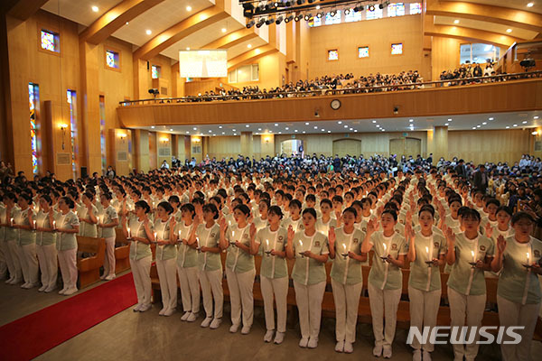 【대전=뉴시스】유순상 기자 = 26일 대전과학기술대학교 성지관에서 열린 '제78회 나이팅게일 선서식'에서 간호학과 2학년 296명이 촛불의식을 거행하고 있다. 이들은 임상실습에 앞서 나이팅게일의 사랑과 헌신, 간호정신을 되새기고 다짐했다. 2018.10.26.(사진=대전과학기술대 제공) ssyoo@newsis.com