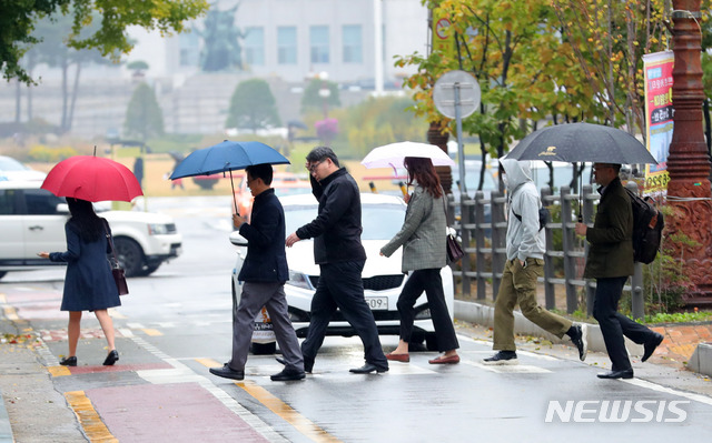 【서울=뉴시스】배훈식 기자 = 전국이 흐리고 해상에 강풍·풍랑 예비특보가 내려진 26일 오전 서울 여의도 의사당대로에서 우산을 쓴 시민들이 출근길 발걸음을 재촉하고 있다. 기상청은 비가 그친 뒤 기온이 뚝 떨어질 것으로 예상돼 외출시 따뜻한 옷차림을 당부했다. 2018.10.26. dahora83@newsis.com
