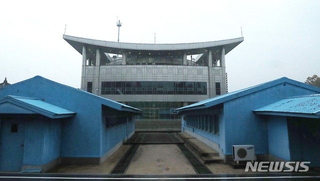 【파주=뉴시스】 사진공동취재단 = '판문점 공동경비구역의 비무장화'를 위해 판문점 공동경비구역(JSA) 내 초소와 화기가 지난 25일 오후 1시부로 철수됐다. 26일 오전 가을비가 내리는 가운데 남북 대치 군인들이 아무도 없이, 버스를 타고 이동하면서 북측 통일각에서 바라본 남측 자유의 집이 보인다. 2018.10.26. photo@newsis.com