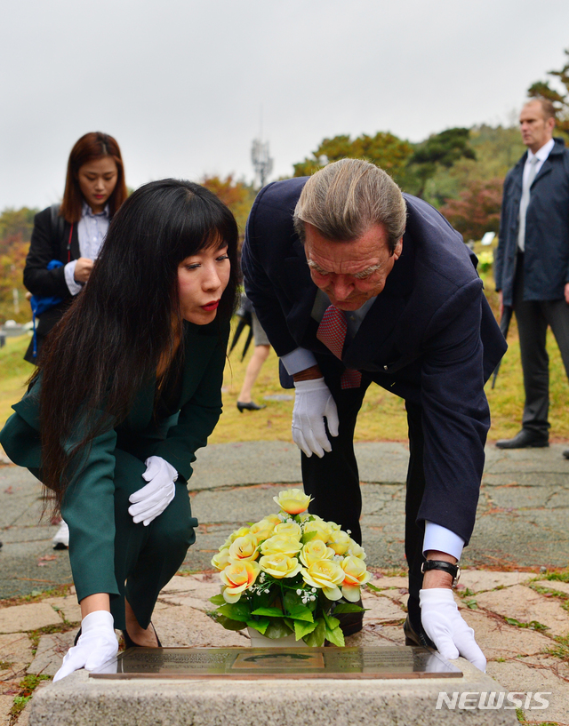 【광주=뉴시스】변재훈 기자 = 게르하르트 슈뢰더 전 독일 총리 부부가 26일 오후 광주 북구 망월동 민족민주열사 묘역을 찾아 5·18을 세계에 알린 위르겐 힌츠페터의 유해가 안장돼 있는 추모비를 어루만지고 있다. 2018.10.26. wisdom21@newsis.com