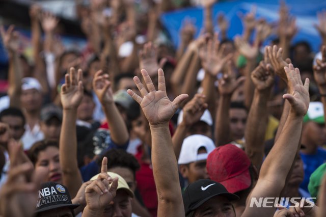 【아리아가(멕시코)=AP/뉴시스】 26일(현지시간) 캐러밴본진이 멕시코 치아파스주 북쪽 아리아가에서 연 투표에서 이민자들 다수자 멕시코 망명 신청을 하지 않겠다며 손을 들고 있다. 이날 엔리케 페냐 니에토 멕시코 대통령은 캐러밴에 난민 지위를 신청할 경우 임시 신분증과 일자리를 제공하겠다는 계획을 발표했다. 2018.10.27.