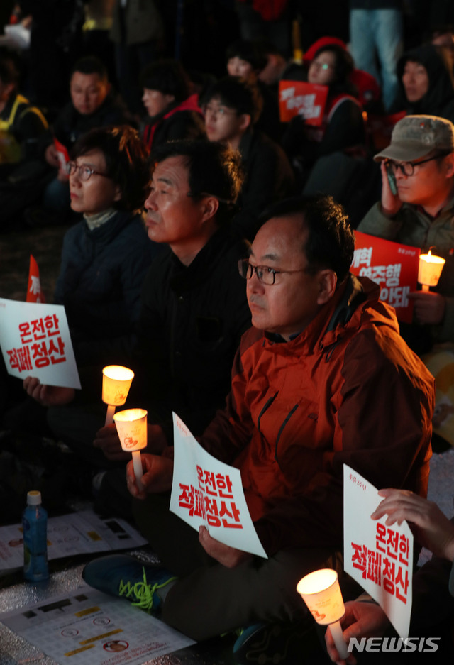 【서울=뉴시스】홍효식 기자 = 27일 오후 서울 종로구 광화문 광장에서 열린 '박근혜 퇴진촛불 2주년 대회'에서 참가자들이 촛불과 피켓을 들고 온전한 적폐청산과 개혁 역주행 반대를 촉구하고 있다. 2018.10.27. yesphoto@newsis.com