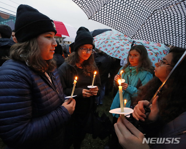 【피츠버그=AP/뉴시스】 미국 펜실베니아주 피츠버그의 스쿼럴 힐에 있는 유대교 예배당에서 27일(현지시간) 총기 난사 사건이 발생해 최소 11명이 숨지고 6명이 중상을 입었다. 사진은 사건이 일어난 예배당 인근에서 시민들이 우산을 쓴채 희생자들을 위해 추모의 촛불을 들고 있는 모습. 이번 사건의 범인은 로버트 바우어스란 40대 남성으로, 범행 직전 "유대인 다 죽어라"라고 외친 것으로 알려졌다. 2018.10.28 