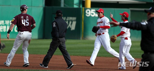 【인천=뉴시스】추상철 기자 = 28일 오후 인천 미추홀구 SK행복드림구장에서 열린 2018 KBO 포스트시즌 플레이오프 2차전 넥센 히어로즈와 SK 와이번스의 경기. 3회초 1아웃 주자1루 상황에서 넥센 박병호의 타격으로 1루주자 샌즈가 2루 진루시 아웃된 후 SK 김성현이 가운데 손가락을 들어보이고 있다. 2018.10.28.scchoo@newsis.com