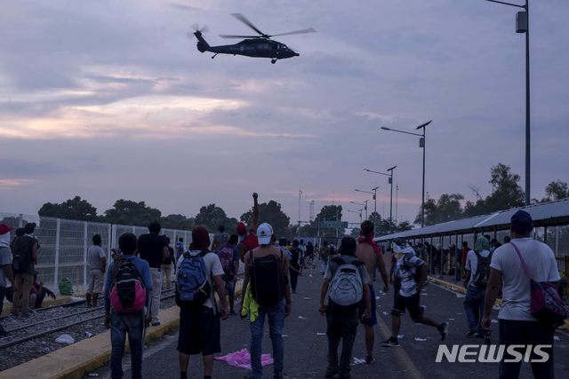 【테쿤우만=AP/뉴시스】과테말라 테쿤우만 접경지역에서 28일(현지시간) 불법 이주민들이 미국으로 갈 수있도록 국경을 열라며 멕시코 경찰들과 대치하고 있다. 2018.10. 29 