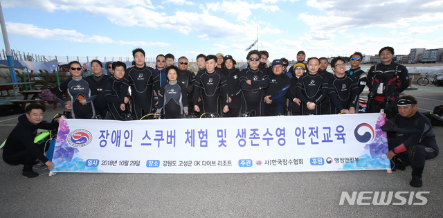 【고성(강원)=뉴시스】김경목 기자 = 29일 오후 ㈔한국잠수협회(KUDA 회장 유대수) 홍성훈 사무국장 등 소속 협회 강사들과 ㈔대한안마사협회 경기지부 부설 안마수련원 소속 시각장애인들이 강원도 고성군 토성면 천진리 스쿠버다이빙숍 'OK다이브리조트' 인근 바다에서 스쿠버다이빙 및 이함(離艦) 체험을 하기 전 기념사진을 촬영하고 있다. 2018.10.29.&nbsp; photo31@newsis.com