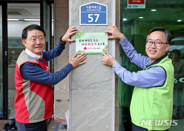 【서울=뉴시스】 금천구는 29일 하누리 장애인 주간보호시설 환경개선사업 완료기념 현판식을 가졌다. 사진 왼쪽 하석주 롯데건설 대표이사, 오른쪽 유성훈 금천구청장. (사진= 금천구청 제공) photo@newsis.com