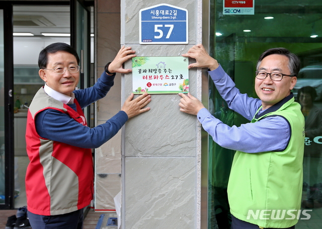 【서울=뉴시스】 금천구는 29일 하누리 장애인 주간보호시설 환경개선사업 완료기념 현판식을 가졌다. 사진 왼쪽 하석주 롯데건설 대표이사, 오른쪽 유성훈 금천구청장. (사진= 금천구청 제공) photo@newsis.com