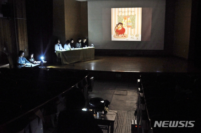 어룡초 책사랑이 맘 학부모들이 학생들과 그림 동화를 시청하고 있다.