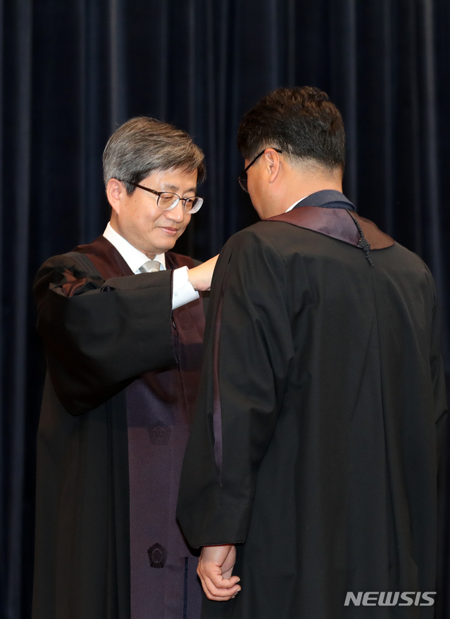 【서울=뉴시스】김선웅 기자 = 1일 오후 서울 서초구 대법원에서 열린 신임법관 임명장 수여식에서 김명수 대법원장이 신임 법관에게 법복을 입혀주고 있다. 2018.11.01. mangusta@newsis.com