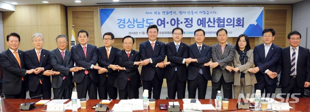【창원=뉴시스】 홍정명 기자 = 5일 국회의원회관 제1세미나실에서 내년도 국비 증액 확보를 논의하기 위해 마련된 '경상남도 여·야·정 합동 예산협의회'에 참석한 김경수 도지사와 경남 출신 여야 국회의원들이 손을 맞잡고 기념촬영을 하고 있다. 이날 예산협의회는 경남도정 사상 처음으로 여야 국회의원이 함께했다.2018.11.05.(사진=경남도 제공) photo@newsis.com