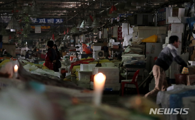 【서울=뉴시스】고승민 기자 = 노량진 구시장 이전 갈등과 관련해 수협이 사전고지 후 시장 전역에 단전 및 단수를 시행한 5일 오후 서울 노량진 구 수산시장이 어두컴컴하다. 일부 상인이 촛불을 켜고 있다. 수협 관계자는 "상인과 고객에 대한 영업 피해를 최소화하기 위해 단전·단수를 오전 9시부터 실시했다"며 "지난 달 23일까지 4차례 명도집행을 실시했으나 불법시장 상인 및 노점상 연합회의 집단 폭력행위로 무산됐다. 명도집행으로 더 이상 정상화할 수 없다는 판단 하에 단전과 단수를 시행하게 됐다"고 밝혔다. 상인들에 따르면 현재 물은 나오고 있지만 전기는 여전히 끊긴 상태다. 상인들은 수협의 이 같은 조치를 받아들일 수 없다는 입장이어서 갈등은 한층 더 심화될 것으로 예상된다. 2018.11.05. kkssmm99@newsis.com