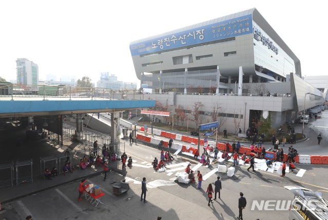 【서울=뉴시스】고승민 기자 = 노량진 구시장 이전 갈등과 관련해 수협이 사전고지 후 시장 전역에 단전 및 단수를 시행한 5일 오후 서울 노량진 구 수산시장과 신시장 사이에서 구시장 상인들이 주차장 입구를 막고 농성을 이어가고 있다. 2018.11.05.kkssmm99@newsis.com