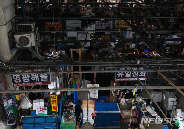 【서울=뉴시스】이영환 기자 = 수협이 노량진 수산시장 구시장 전역에 단전과 단수를 진행한지 하루 지난 6일 오전 서울 동작구 노량진 수산시장 구시장이 어둑어둑한 가운데 상인들이 촛불을 켜고 장사를 하고 있다. 2018.11.06.&nbsp; 20hwan@newsis.com