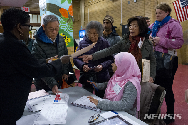 【뉴욕=AP/뉴시스】 6일 미 중간선거 뉴욕시 브루클린구(카운티)의 한 투표 소에서 두 명의 투표 종사원들이 투표 유권자를 응대하고 있다. 미국 시민권자로서 사전에 자발적 유권자등록을 해야 투표할 수 있다. 2018. 11. 6.