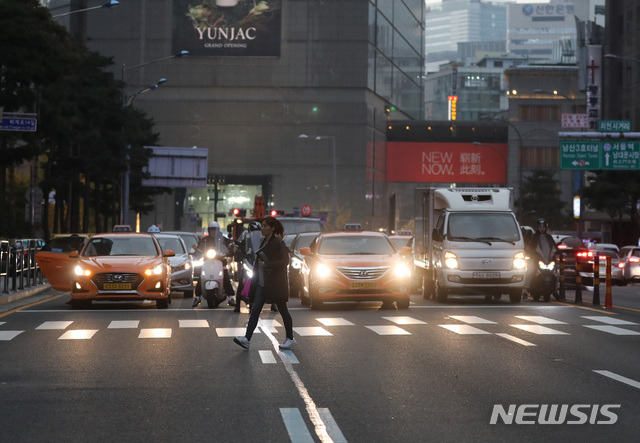 【서울=뉴시스】전진환 기자 = 미세먼지 비상저감조치가 내려진 7일 오후 서울 명동 도로에서 먼지와 먹구름에 자동차들이 전조등을 켜고 운행하고 있다. 2018.11.07.&nbsp; amin2@newsis.com