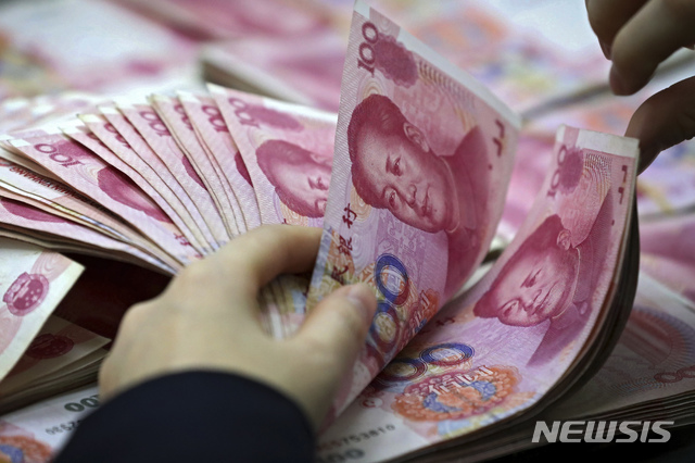 【화이베이=AP/뉴시스】중국 안후이성 화이베이시의 한 은행에서 직원이 위안화를 세고 있다. 17일 역외시장에서 위안화 가치가 폭락하며 위안화-달러 환율이 연고점을 기록했다. 2019.05.17.