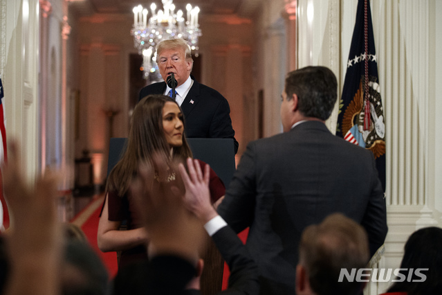 【워싱턴=AP/뉴시스】 7일 (현지시간) 열린 기자회견에서 백악관 직원이 CNN 짐 아코스타 기자에게 마이크를 받으려 다가가던 중 도널드 트럼프 미국 대통령이 이들을 바라보고 있다. 트럼프 대통령은 이날 아코스타 기자와 언쟁을 벌였다. 2018.11.8.