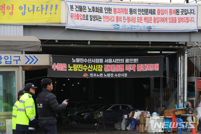 【서울=뉴시스】배훈식 기자 = 노량진 구(舊) 수산시장 철거가 시작되는 9일 오전 서울 동작구 구 시장 앞에서 경찰들이 만일의 사태에 대비해 경계를 하고 있다. 수협중앙회는 이날 오후 5시까지 신 시장 이전 신청을 접수한 뒤 철거에 들어가겠다며 최후통첩을 한 상황이다. 2018.11.09. dahora83@newsis.com