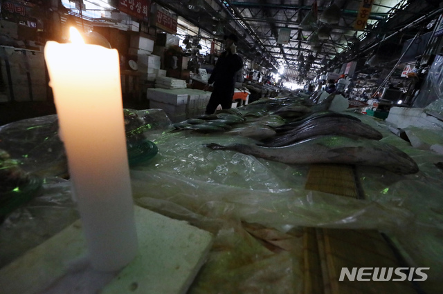 【서울=뉴시스】고승민 기자 = 노량진 구시장 이전 갈등과 관련해 수협이 사전고지 후 시장 전역에 단전 및 단수를 시행한 5일 오후 서울 노량진 구 수산시장이 어두컴컴하다. 일부 상인이 촛불을 켜고 있다. 수협 관계자는 "상인과 고객에 대한 영업 피해를 최소화하기 위해 단전·단수를 오전 9시부터 실시했다"며 "지난 달 23일까지 4차례 명도집행을 실시했으나 불법시장 상인 및 노점상 연합회의 집단 폭력행위로 무산됐다. 명도집행으로 더 이상 정상화할 수 없다는 판단 하에 단전과 단수를 시행하게 됐다"고 밝혔다. 상인들에 따르면 현재 물은 나오고 있지만 전기는 여전히 끊긴 상태다. 상인들은 수협의 이 같은 조치를 받아들일 수 없다는 입장이어서 갈등은 한층 더 심화될 것으로 예상된다. 2018.11.10. kkssmm99@newsis.com 