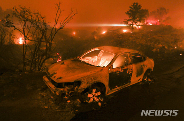 【말리부=AP/뉴시스】 9일(현지시간) 미 캘리포니아 말리부의 한 해안 고속도로에서 차량이 불타고 있다. 캘리포니아 남부에서 발생한 산불은 바람을 타고 바다 쪽으로 이동 중이다. 2018.11.10.