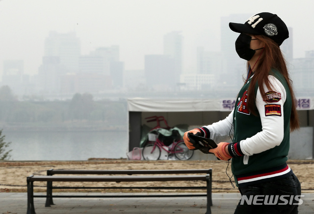 【서울=뉴시스】최진석 기자 = 서울지역 미세먼지 농도가 나쁨 수준을 보이고 있는 11일 오전 서울 광진구 뚝섬 한강공원에서 시민이 마스크를 쓰고 산책을 하고 있다.  2018.11.11. myjs@newsis.com