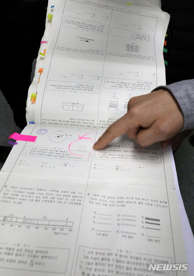 【서울=뉴시스】박주성 기자 = 12일 오전 서울 강남구 서울 수서경찰서에서 열린 숙명여고 문제유출 사건 수사결과 발표에서 전 교무부장 A씨와 두 딸들에게서 압수한 압수물들을 경찰 관계자가 취재진에게 설명하고 있다. 사진은 정답표가 시험지 위에 작게 적혀있는 모습. 2018.11.12. park7691@newsis.com