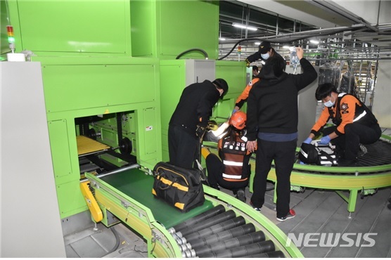 【서울=뉴시스】운송용 컨베이어 벨트 장치에 몸이 낀 하청노동자 문모(42)씨를 구조 중인 소방대원. 2018.11.13. (사진=서울 금천소방서 제공)